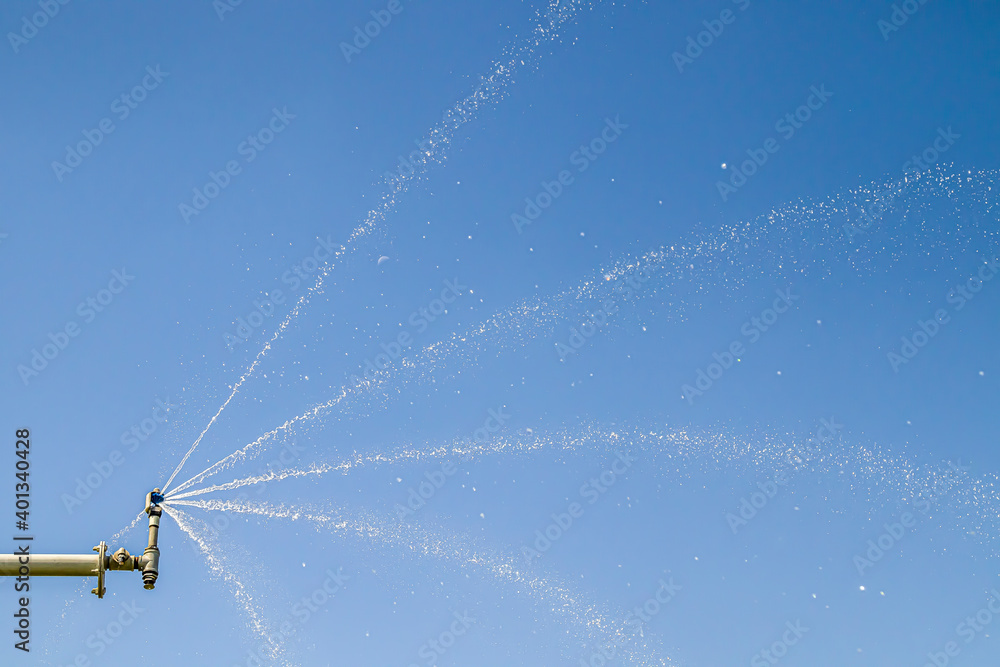 Sprinkler system sprays water against the sky Sprinkler system sprays water against the sky