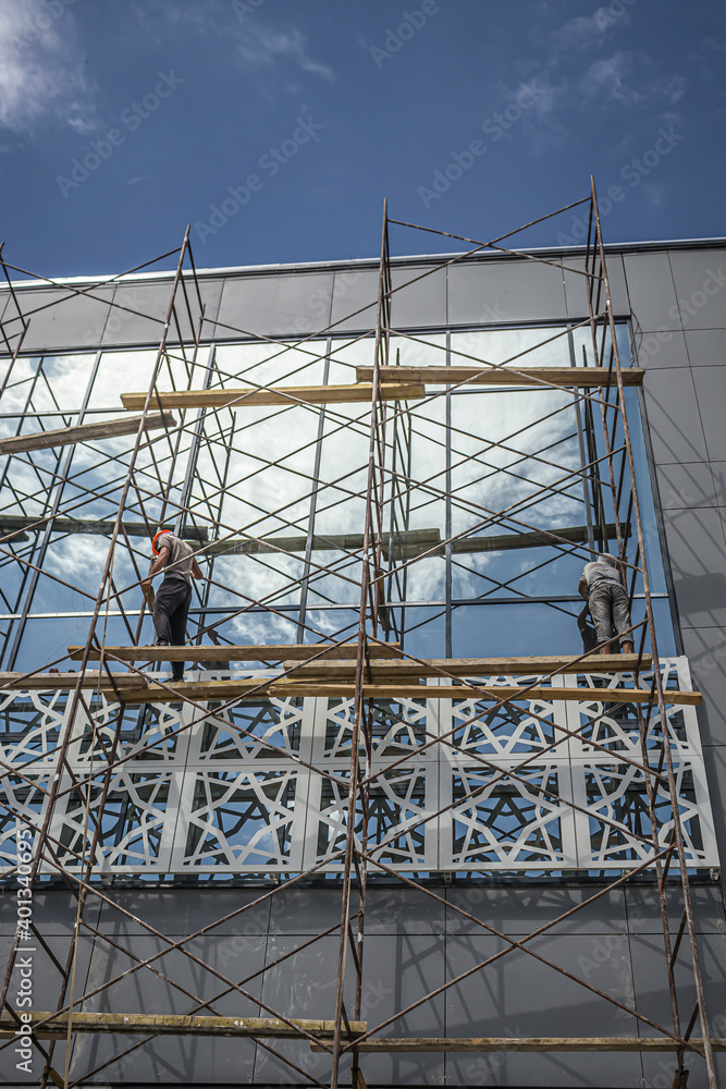 Modern glass building in scaffolding against the sky Modern glass building in scaffolding against the sky
