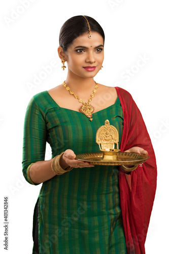 Hindu Indian young women holding Deepam in hands isolated on white. ( Kamatchi vilakku ) photo