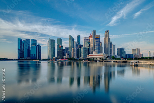 Wide panorama image of Singapore skyscrapers illuminated by morning sunlight early in the morning.