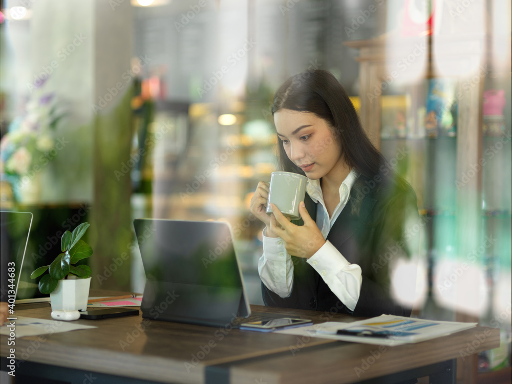 Businesswoman take a coffee break while working with tablet in cafe Businesswoman take a coffee break while working with tablet in cafe