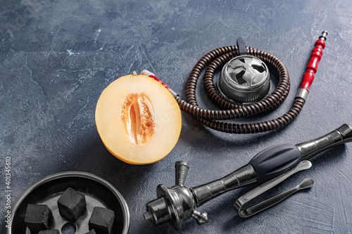 Parts of hookah and melon on dark background