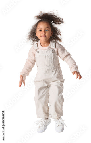 Jumping African-American baby girl on white background