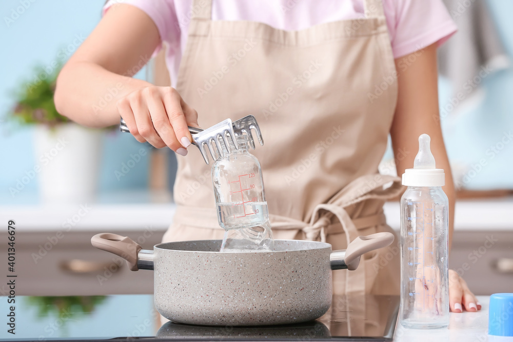 Woman cleaning baby bottle at home Stock Photo Adobe Stock