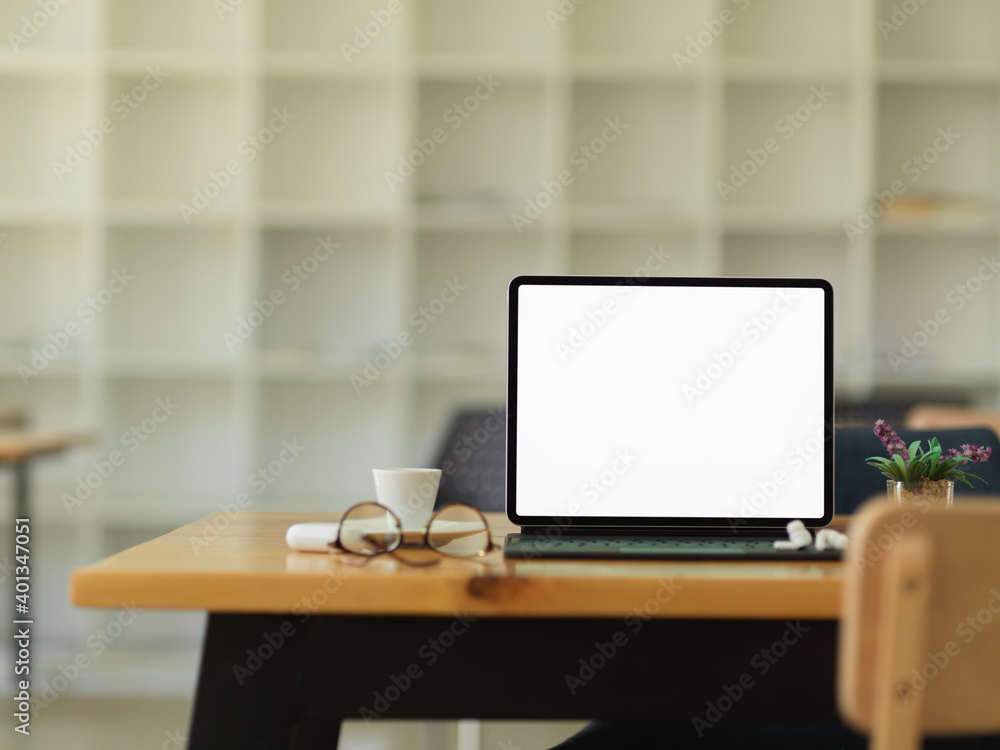 Worktable with digital tablet and office supplies in modern office room Worktable with digital tablet and office supplies in modern office room