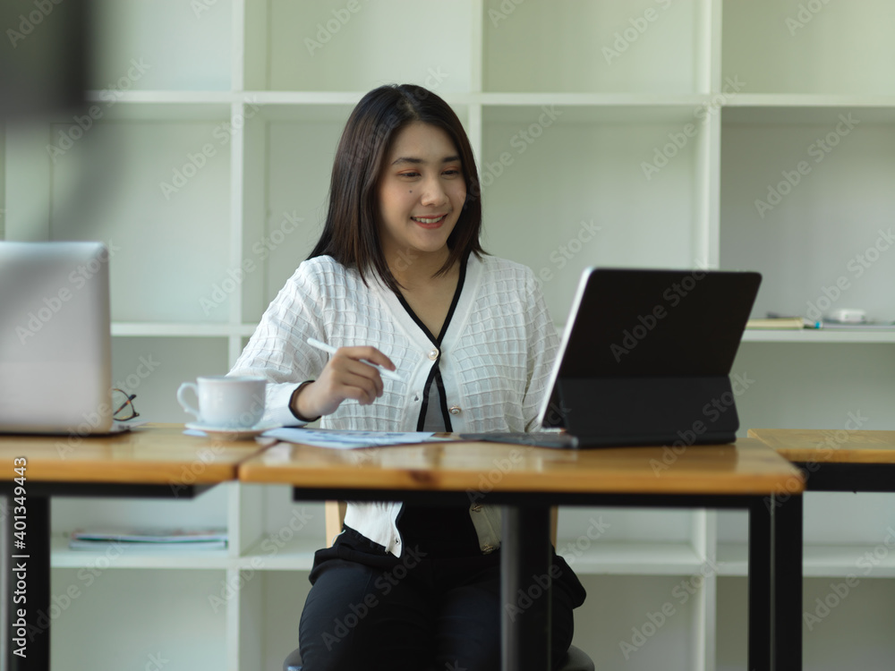 Businesswoman working with tablet and laptop in office room Businesswoman working with tablet and laptop in office room