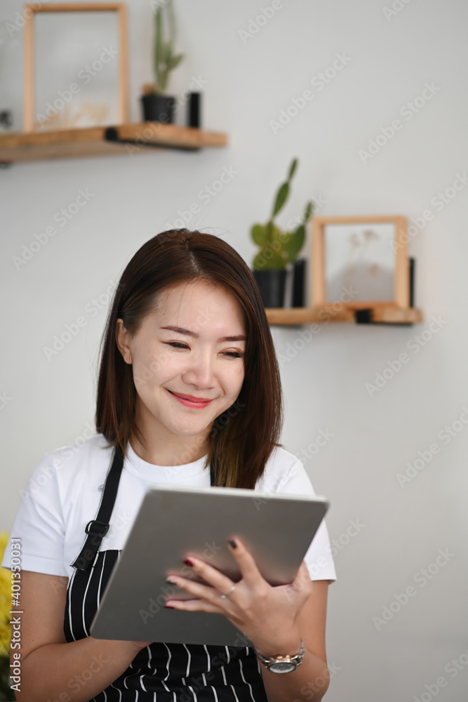 Portrait of successful owner woman and using digital tablet while sitting in her coffee shop. Portrait of successful owner woman and using digital tablet while sitting in her coffee shop.