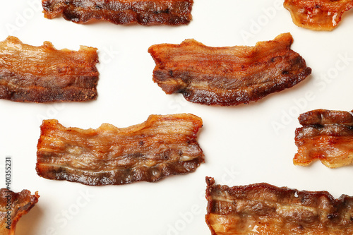 Tasty fried bacon slices on white background