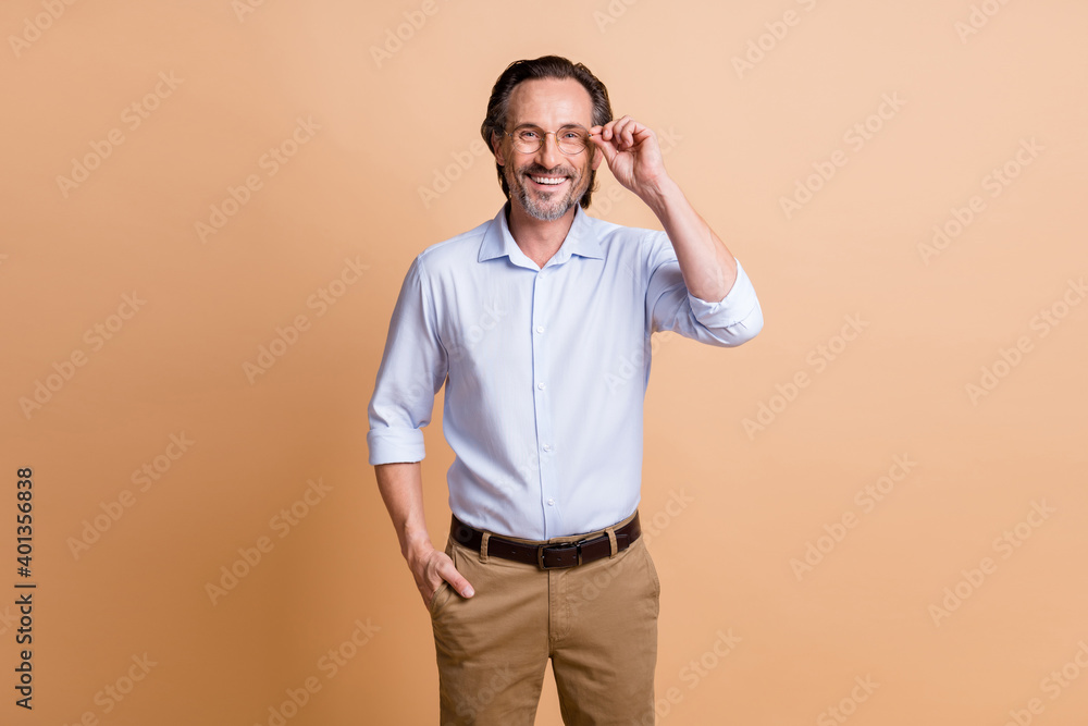 Photo of self-assured mature man hold eyeglasses look camera wear specs shirt isolated beige color background Photo of self-assured mature man hold eyeglasses look camera wear specs shirt isolated beige color background