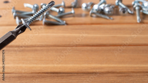 A screwdriver and self-cutters on a brown wooden background. Building tools to repair the house.