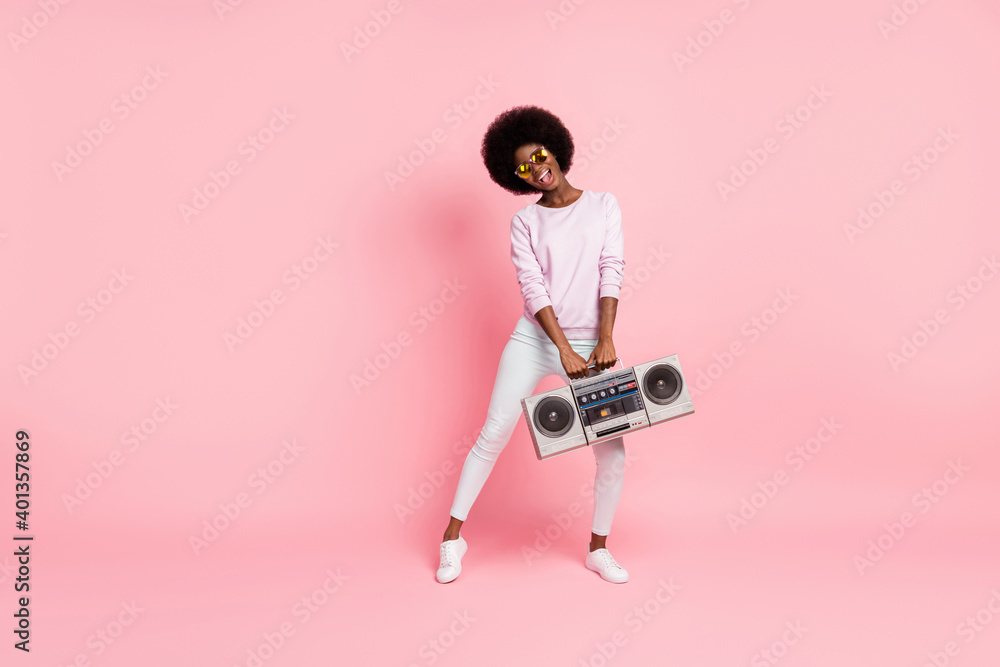 Full length body size view of nice cheerful wavy-haired girl carrying tape retro player having fun moving clubbing isolated on pink color background