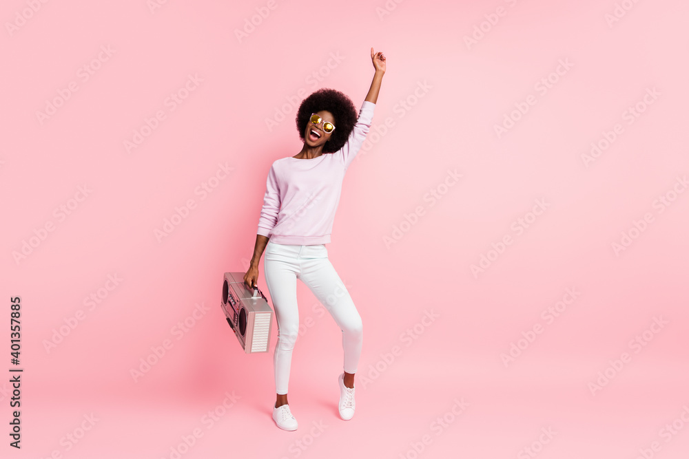 Full length body size view of nice skinny cheerful wavy-haired girl carrying cassette player having fun isolated on pink color background Full length body size view of nice skinny cheerful wavy-haired girl carrying cassette player having fun isolated on pink color background