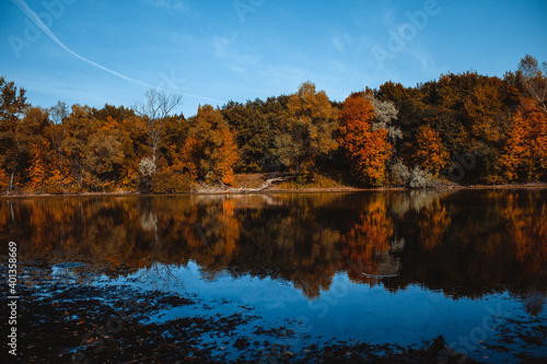 lake on the background of autumn forest and blue sky