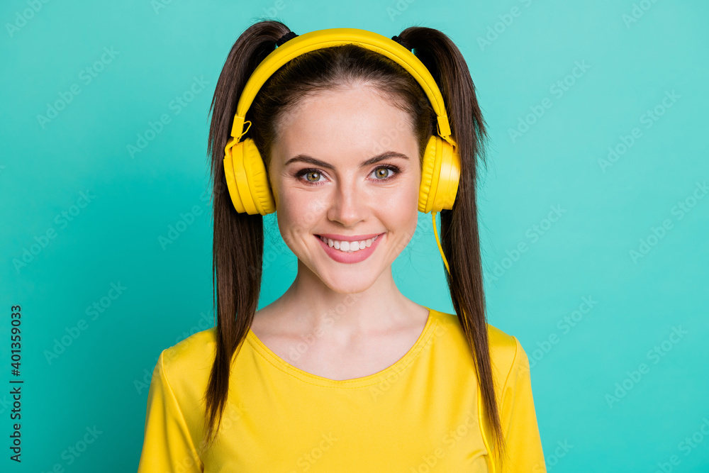 Portrait of nice optimistic brunette girl wear headphones t-shirt isolated on blue color background Portrait of nice optimistic brunette girl wear headphones t-shirt isolated on blue color background