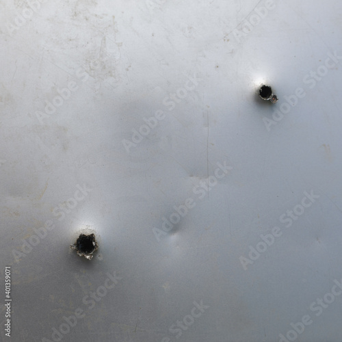 Photo bullet ragged hole in sheet metal wall or door