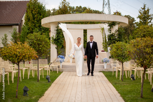 Beautiful wedding couple. The bride and groom are walking at the wedding ceremony. The bride in a beautiful dress тhe groom is dressed stylishly