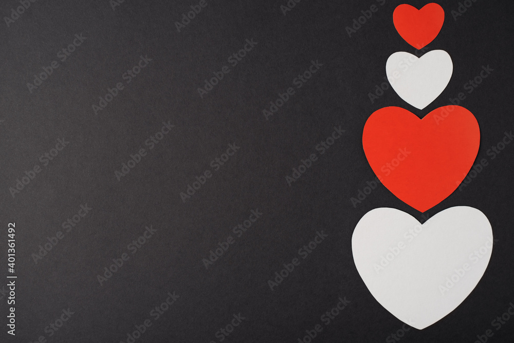 Paper hearts over the black background. Abstract background with paper cut shapes. Saint Valentine, mother's day, birthday greeting cards, invitation, celebration concept Paper hearts over the black background. Abstract background with paper cut shapes. Saint Valentine, mother's day, birthday greeting cards, invitation, celebration concept