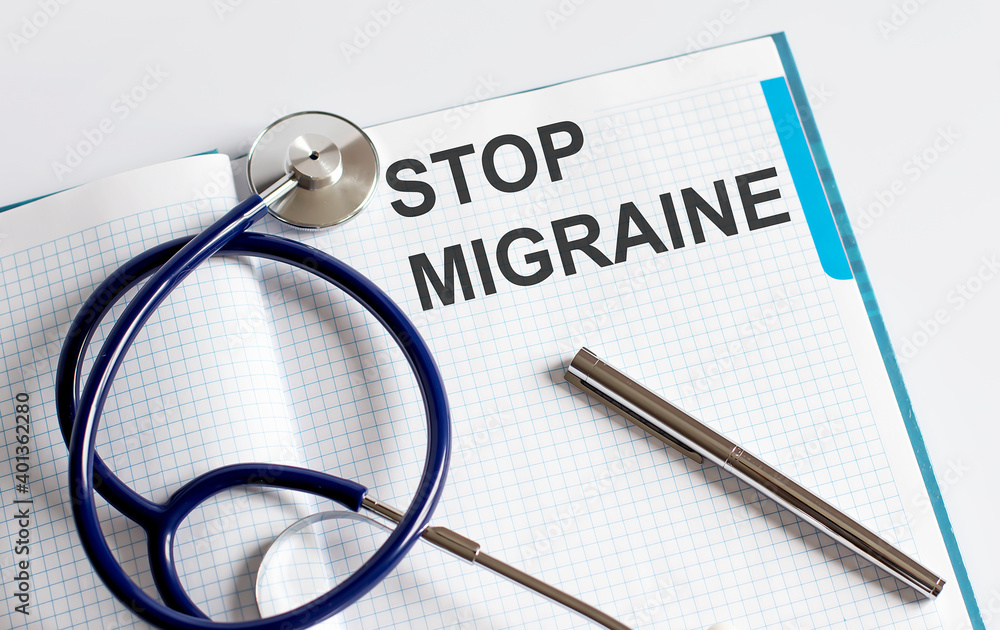 Paper with text STOP MIGRAINE on table with stethoscope Paper with text STOP MIGRAINE on table with stethoscope