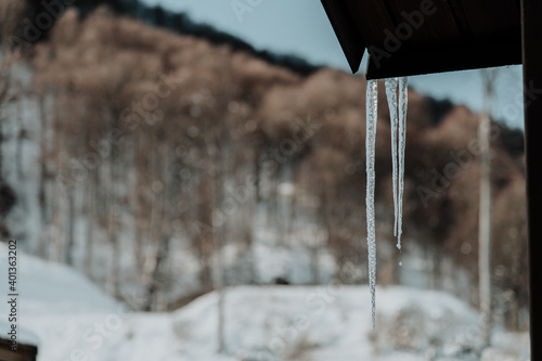 Icicle on the roof of the house, in focus, close-up. photo