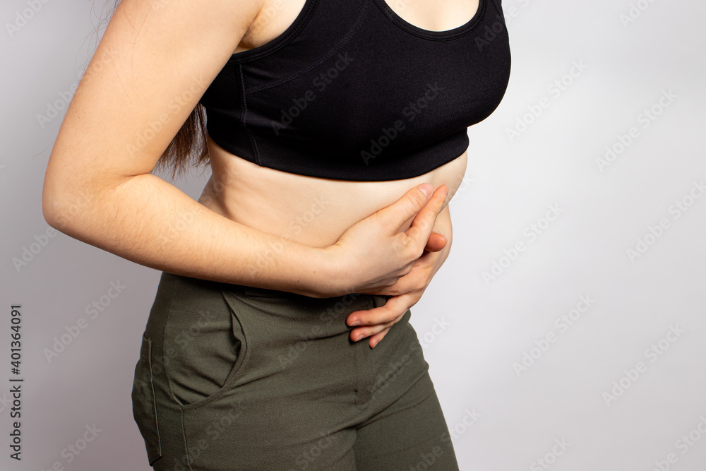 A woman's stomach hurts. Abdominal pain due to gastritis, stomach ulcers and Crohn's disease