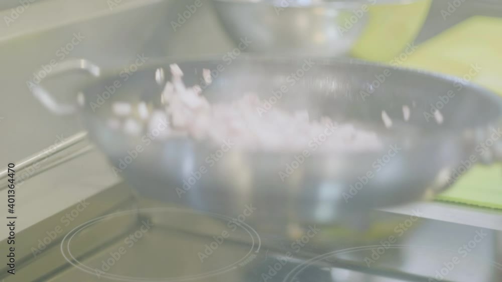 A chef is moving the sliced bacon on a pan in the kitchen of a hotel's restaurant. A chef is moving the sliced bacon on a pan in the kitchen of a hotel's restaurant.