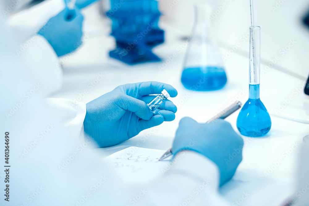 rear view. scientist recording the results of investigations in a laboratory journal . rear view. scientist recording the results of investigations in a laboratory journal .