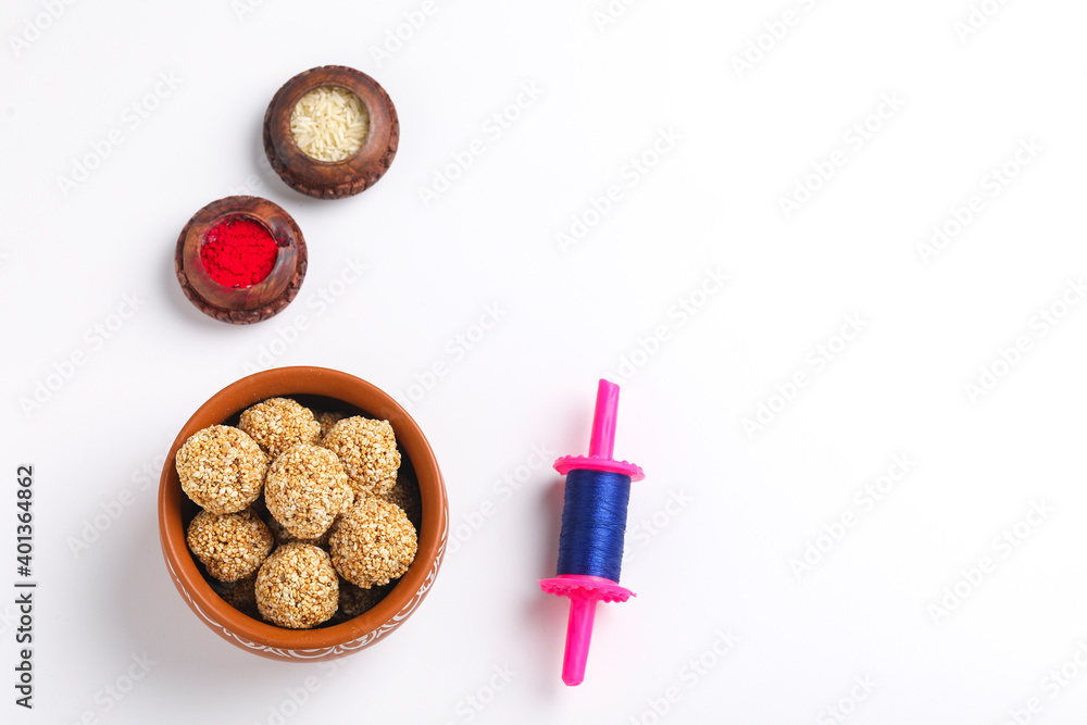 Til Gul OR Sweet Sesame seed ball or Laddu with Fikri for Indian festival Makar Sankranti over white background Til Gul OR Sweet Sesame seed ball or Laddu with Fikri for Indian festival Makar Sankranti over white background