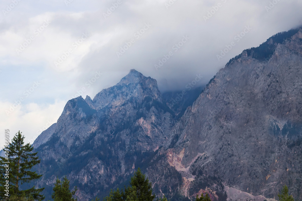 Fototapeta premium Beautiful Alpine mountainous scenery on the road to the city of Siena, Tuscany, Italy. Alps mountains on cloudy and foggy day. Soft selective focus, long exposure