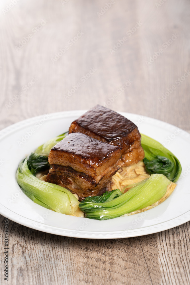 ong Po Pork meat in a blue plate with broccoli with red background. ong Po Pork meat in a blue plate with broccoli with red background.