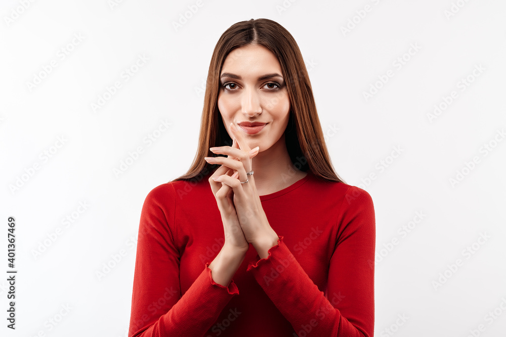 Photo of attractive female in casual red sweater making up plan in mind. Studio shot, white background Photo of attractive female in casual red sweater making up plan in mind. Studio shot, white background