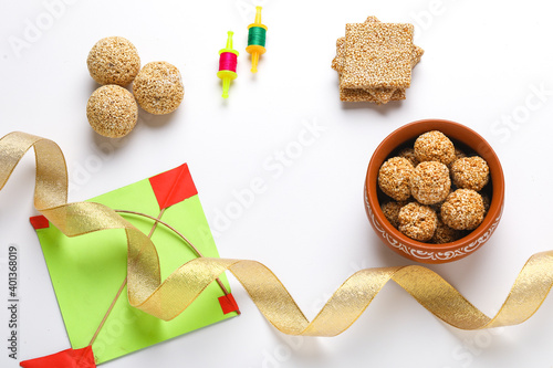 Til Gul OR Sweet Sesame seed ball or Laddu with Fikri for Indian festival Makar Sankranti over white background photo