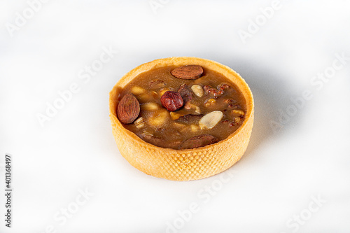 Shortcrust pastry tart with nuts and caramel on a light background. Home delivery. Festive concept. Quarantine.
