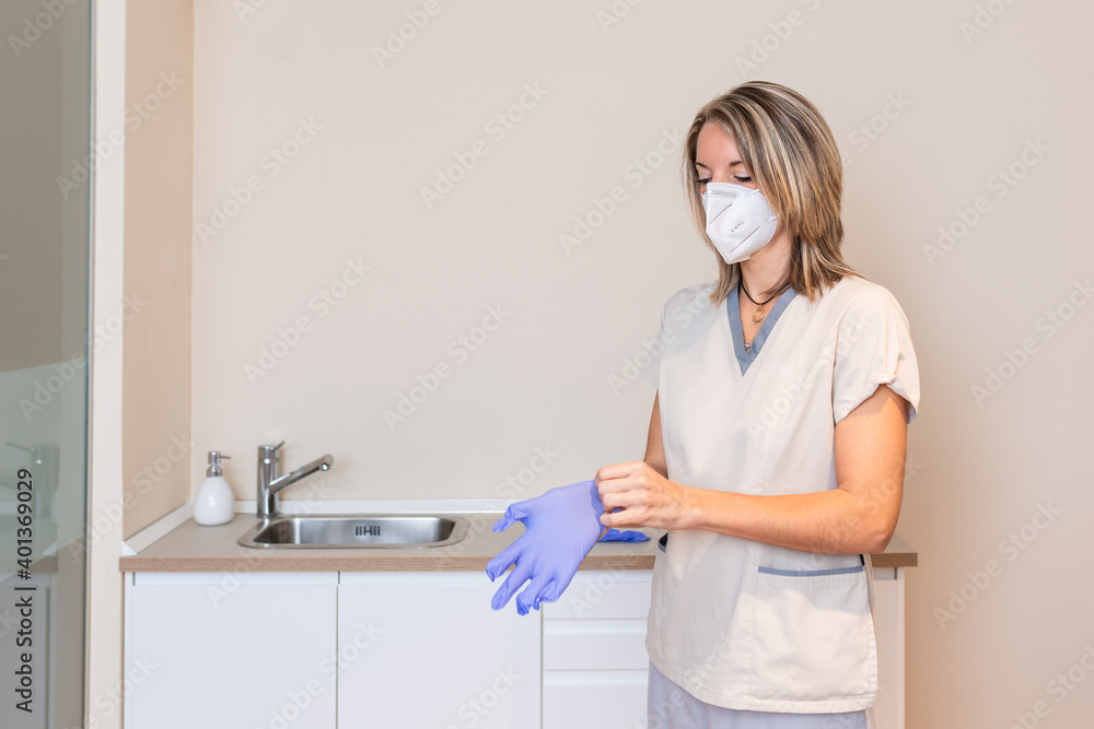 Medicine and professional skills concept. woman physiotherapist puts glove on Medicine and professional skills concept. woman physiotherapist puts glove on