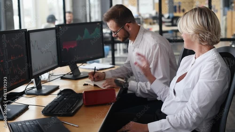 Male and female stockbrokers in formal clothes in the office taking a break and throwing money into the air by special tool. Male and female stockbrokers in formal clothes in the office taking a break and throwing money into the air by special tool.