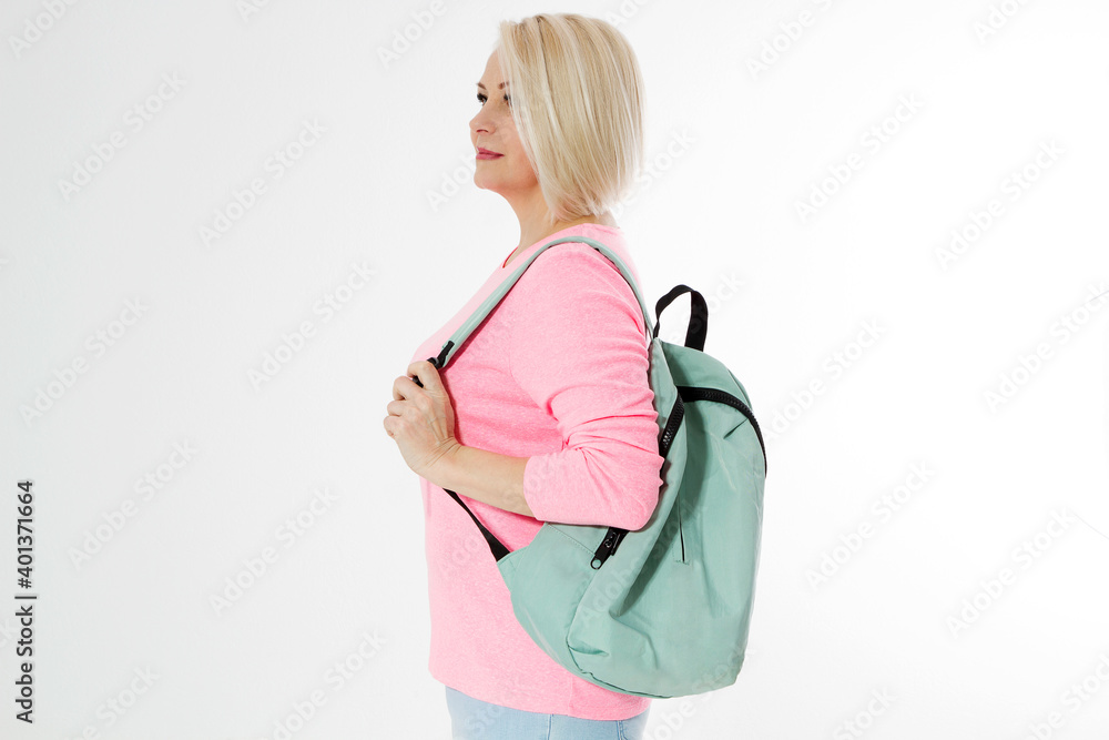 Sporty happy middle age beautiful woman with backpack isolated on white background. Copy space. Mid aged women healthy lifestyle. Menopause, active life. Female going to workout. Healthy aging people Sporty happy middle age beautiful woman with backpack isolated on white background. Copy space. Mid aged women healthy lifestyle. Menopause, active life. Female going to workout. Healthy aging people