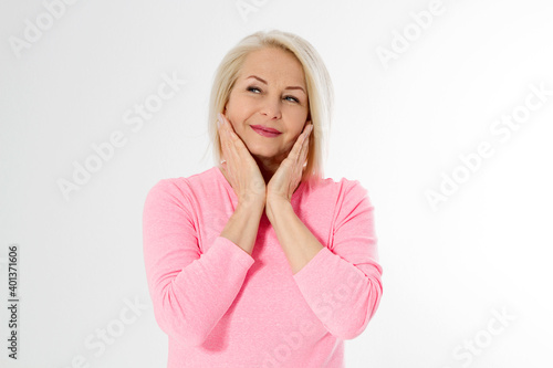Happy beautiful close up portrait middle age blonde woman. Mid aged healthy female isolated on white background with copy space. Menopause and healthcare. Mature lady wrinkled face. Folded hands