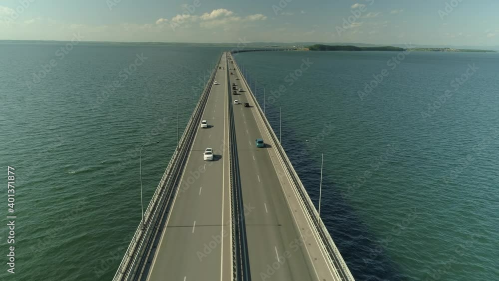 Flight fast backwards low-water bridge over sea Vladivsotok Russia. Road traffic lot of cars ride. Modern cityscape. Sunny sky, cumulus clouds horizon. Travel attraction. Mount your car. Stock 4k Flight fast backwards low-water bridge over sea Vladivsotok Russia. Road traffic lot of cars ride. Modern cityscape. Sunny sky, cumulus clouds horizon. Travel attraction. Mount your car. Stock 4k