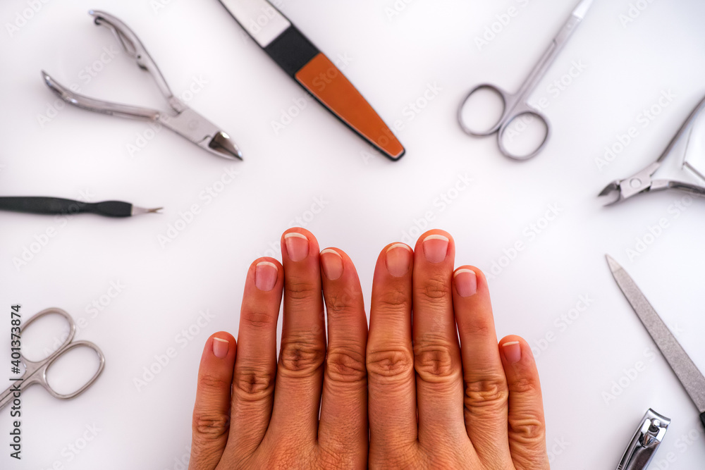 Woman's hands with uncoated manicure and home manicure tools. Woman's hands with uncoated manicure and home manicure tools.