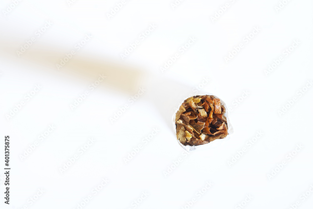 The tip of a cigarette standing on a white background. View from above. Tobacco smoking and other bad habits. Free space for inscription. Macro. The tip of a cigarette standing on a white background. View from above. Tobacco smoking and other bad habits. Free space for inscription. Macro.