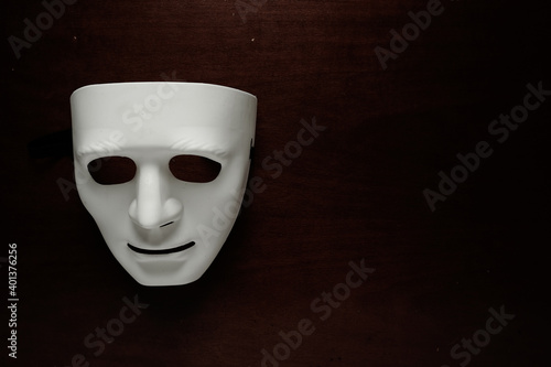 A low key picture of toy face mask on dark background. Depression and psychological problems concept.