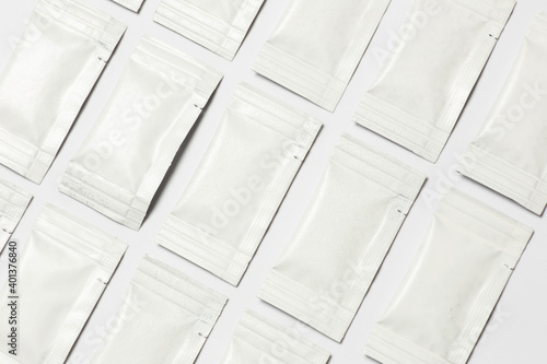 Close-up composition of white sachets on a white background.