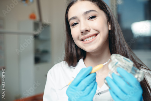 Dentist with blue gloves and long hair in whose hands a cast of the oral cavity