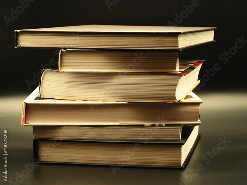 Stapel dicker Bücher im Vintage Look vor schwarzem Hintergrund