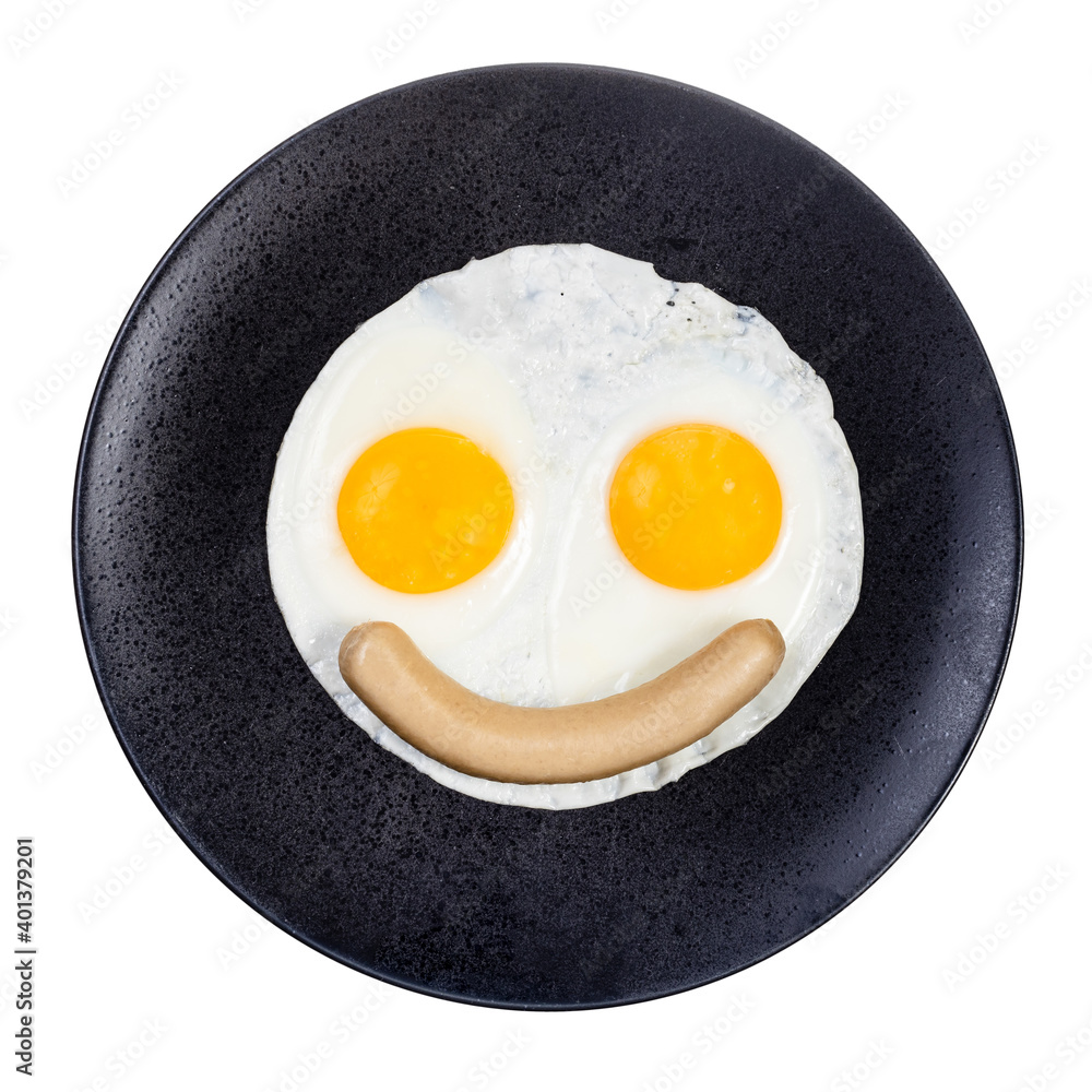 top view of fried eggs and boiled sausage on black plate isolated on white background. Fried eggs like smiling face top view of fried eggs and boiled sausage on black plate isolated on white background. Fried eggs like smiling face