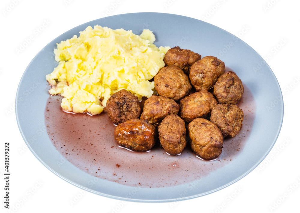 portion of fried swedish meatballs with lingonberry sauce and mashed potatoes on blue plate isolated on white background
