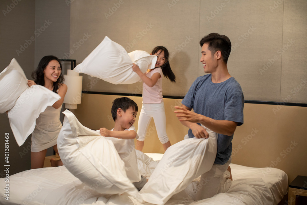Happy young family having fun in bedroom Happy young family having fun in bedroom