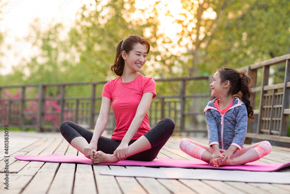 Happy mother and daughter doing yoga outdoors Happy mother and daughter doing yoga outdoors