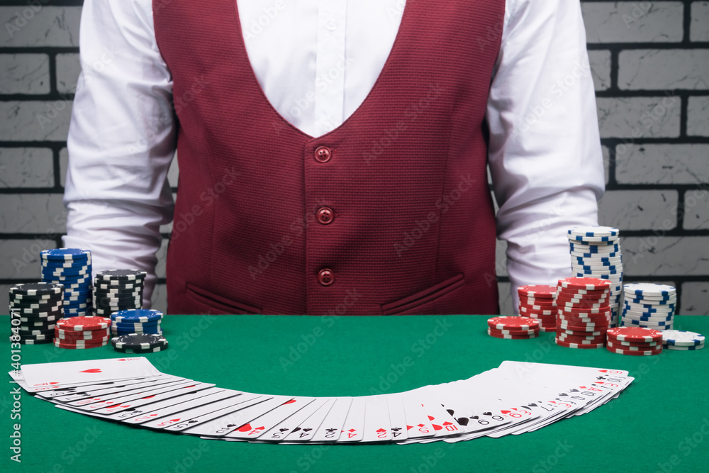 the croupier spreads a deck of cards on the green cloth of the table the croupier spreads a deck of cards on the green cloth of the table