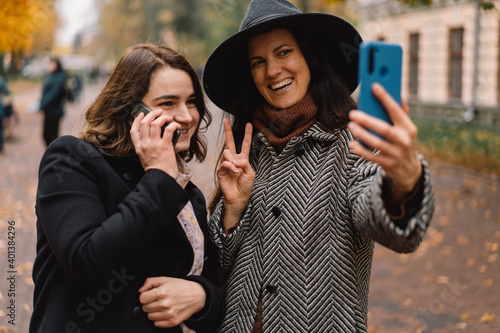 Girls take a selfie on the phone in the park. Friends and lifestyle © Анастасія Стягайло