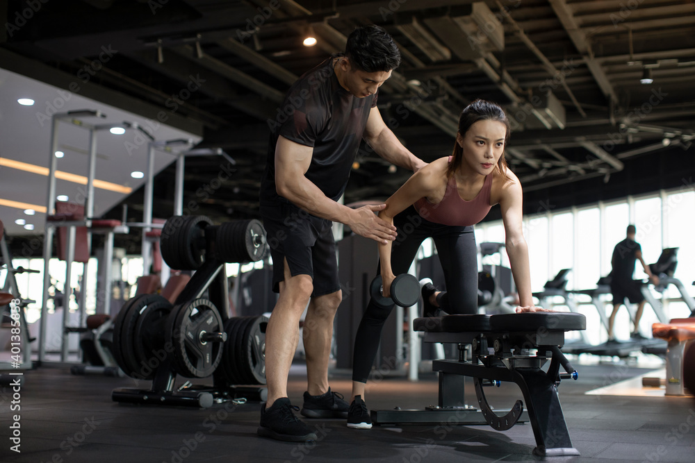 © Blue Jean Images - Young woman working out with personal trainer at gym © Blue Jean Images - Young woman working out with personal trainer at gym